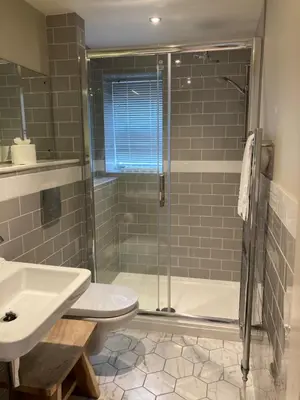 a bathroom with a shower and a toilet and a sink at The Galleon Inn in Fowey