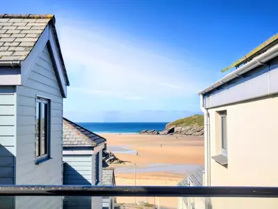 a view of the beach from the balcony of a house at Sandpiper Cottages in Newquay