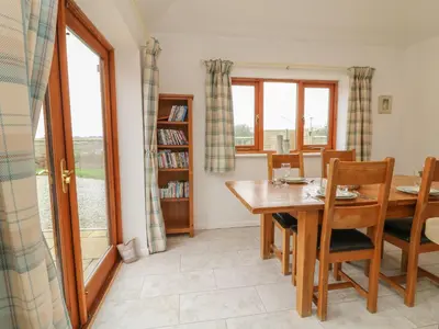 a dining room with a wooden table and chairs at Edwin's View in Helston