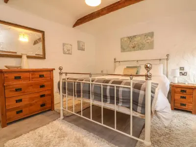 a bedroom with a bed and a dresser at Edwin's View in Helston