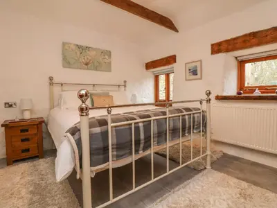 a bedroom with a bed and a window at Edwin's View in Helston