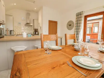 a wooden table with plates and glasses on it in a kitchen at Edwin's View in Helston