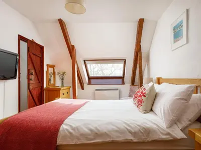 a bedroom with a white bed with a red blanket at Pond Meadow in Launceston