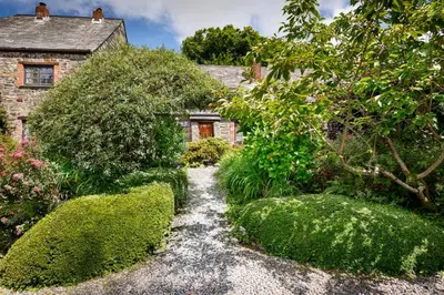 a garden in front of a house with bushes at Pond Meadow in Launceston