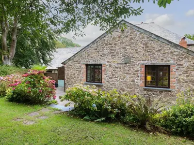 a stone house with flowers in front of it at The Roundhouse in Launceston