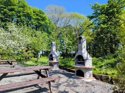 two picnic tables and benches in a park at Beech Cottage in Launceston