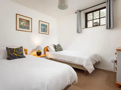 a bedroom with two beds and a window at Ash Cottage in Launceston