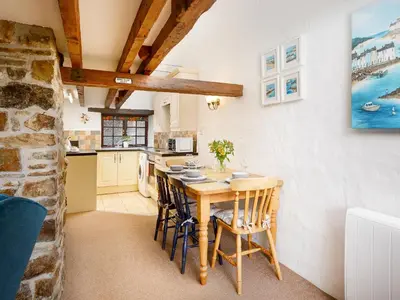 a kitchen and dining room with a wooden table and chairs at Ash Cottage in Launceston