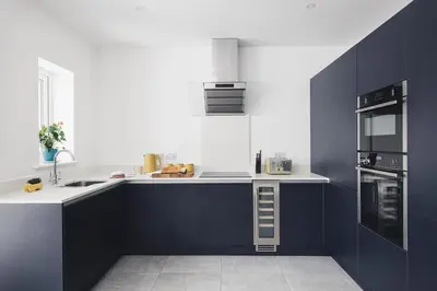 a kitchen with black and white counters and appliances at Ocean-Walk Granny's Lane Perranporth in Perranporth