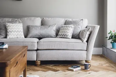 a couch in a living room with pillows on it at Ocean-Walk Granny's Lane Perranporth in Perranporth
