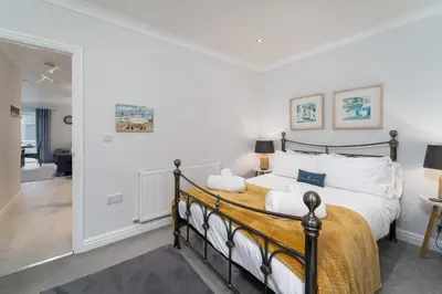 a bedroom with a large bed and a hallway at Sea Shells in St Ives