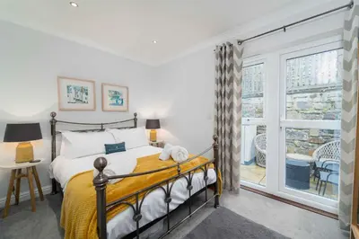 a bedroom with a bed and a large window at Sea Shells in St Ives