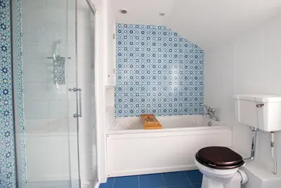 a bathroom with a tub and a toilet and a shower at Villa Louise in St Ives