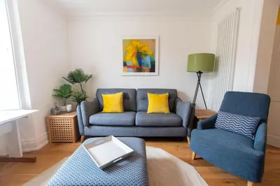 a living room with a blue couch and a chair at Villa Louise in St Ives