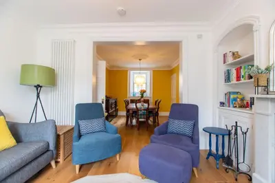a living room with blue chairs and a table at Villa Louise in St Ives