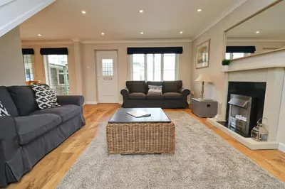 a living room with two couches and a fireplace at BY THE BEACH cottage, dogs welcome in St Merryn