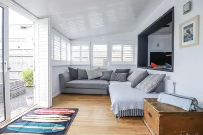 a living room with a couch and a large window at The Three Tees in Newquay