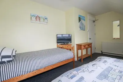 a room with two beds and a television in it at The Three Tees in Newquay