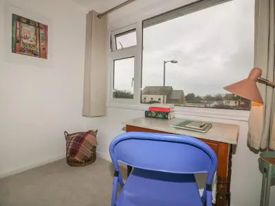 a desk with a blue chair and a window at Eloen in Newquay