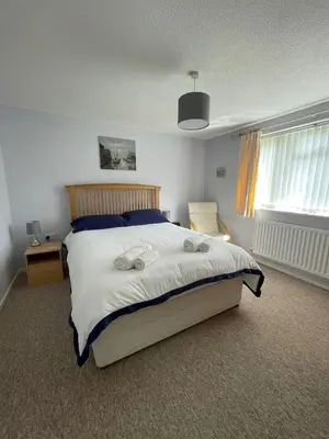 a bedroom with a large bed with towels on it at Sunny detached bungalow, Nr Looe in Saint Keyne