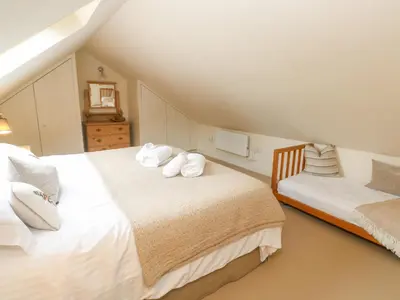 a attic bedroom with two beds with white pillows at No 1 The Hinges in Newquay