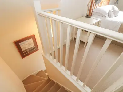 a white staircase with a bed and a table at No 1 The Hinges in Newquay