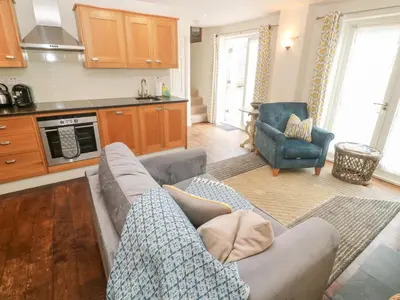 a living room with a couch and a kitchen at No 1 The Hinges in Newquay