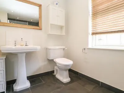 a bathroom with a toilet and a sink and a mirror at No 3 The Hinges in Newquay