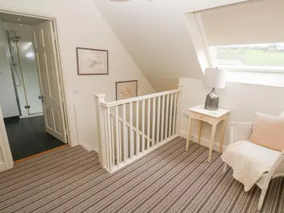 a room with a staircase with a chair and a window at No 3 The Hinges in Newquay