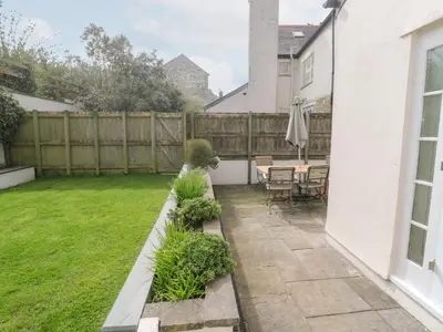 a backyard with a fence and a table and chairs at No 3 The Hinges in Newquay