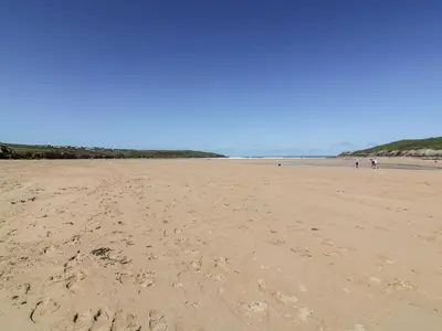 a beach with people walking on the sand at No 3 The Hinges in Newquay