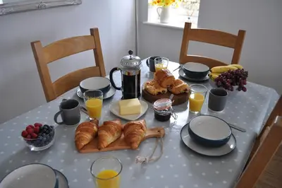 a table with a breakfast of croissants and orange juice at Morley's in Ponsanooth