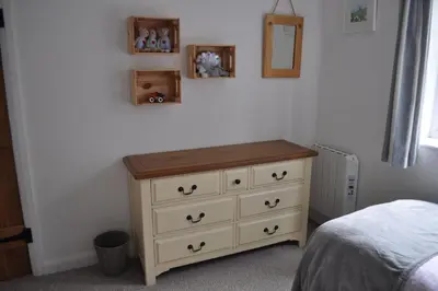 a bedroom with a dresser and a mirror on the wall at Morley's in Ponsanooth