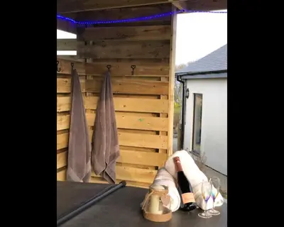 a pair of shoes sitting on a patio with a wooden wall at Morley's in Ponsanooth