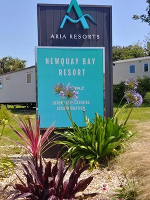a sign for a newbury bay resort with plants at Newquay Bay Resort - SummerBreeze PV54 in Porth