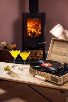 a table with two glasses and a suitcase and a fireplace at The Duchy Barn at Tregoose Old Mill in Newquay