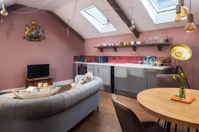 a living room with a couch and a table at The Duchy Barn at Tregoose Old Mill in Newquay