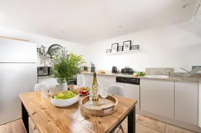 a kitchen with a wooden table with a bowl of fruit on it at Mr Blue Sky in St Ives