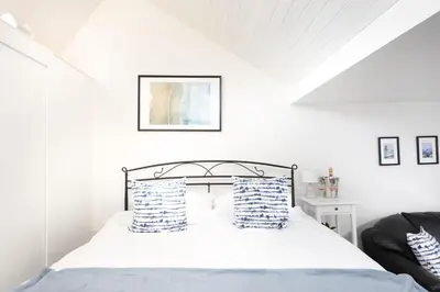 a bedroom with a bed with blue and white pillows at Mr Blue Sky in St Ives