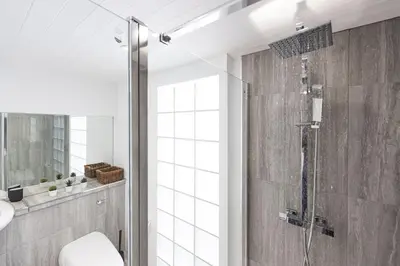 a bathroom with a shower with a toilet and a sink at Mr Blue Sky in St Ives