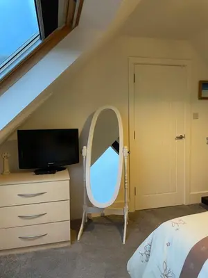 a bedroom with a mirror and a dresser with a tv at The Town House - Newquay in Newquay