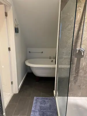 a bathroom with a tub and a glass shower at The Town House - Newquay in Newquay