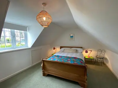 a bedroom with a bed and a large window at Bodriggy Barn Holiday Cottage near St Ives in Hayle