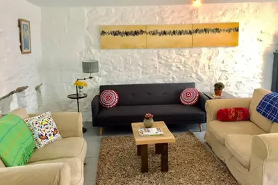 a living room with two couches and a coffee table at Bodriggy Barn Holiday Cottage near St Ives in Hayle
