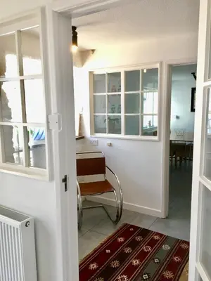 a living room with a chair and a table at Bodriggy Barn Holiday Cottage near St Ives in Hayle