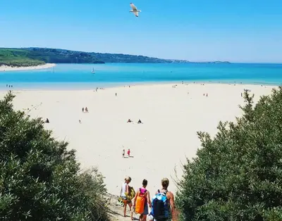 a group of people standing on a beach at Bodriggy Barn Holiday Cottage near St Ives in Hayle