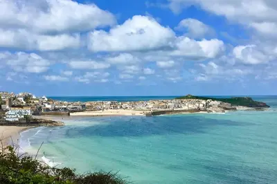 a view of a beach with houses and the ocean at Bodriggy Barn Holiday Cottage near St Ives in Hayle