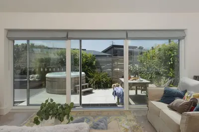 a living room with a large sliding glass door at 6 The Dunes At Upton Towans - Short walk to the beach - Hot Tub - Free Wi-Fi in Hayle