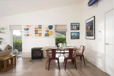 a dining room with a table and chairs and a fireplace at 6 The Dunes At Upton Towans - Short walk to the beach - Hot Tub - Free Wi-Fi in Hayle