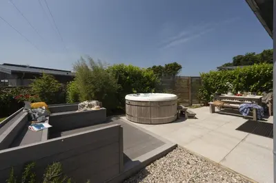 a garden with a hot tub and a patio at 6 The Dunes At Upton Towans - Short walk to the beach - Hot Tub - Free Wi-Fi in Hayle